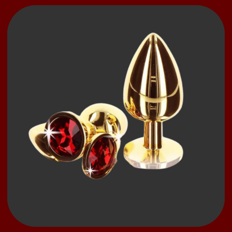 Zlatý anální kolík s červeným drahokamem na základně – elegantní erotická pomůcka v luxusním provedení, dostupná ve třech velikostech.