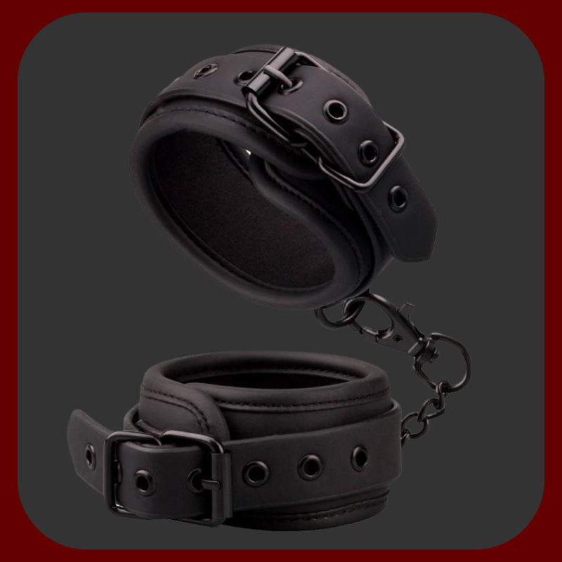 Nastavitelné BDSM pouta z černé veganské ekokůže s kovovým řetízkem bez niklu. Vhodné pro použití na zápěstí i kotníky, s polstrovaným vnitřkem pro pohodlné nošení.